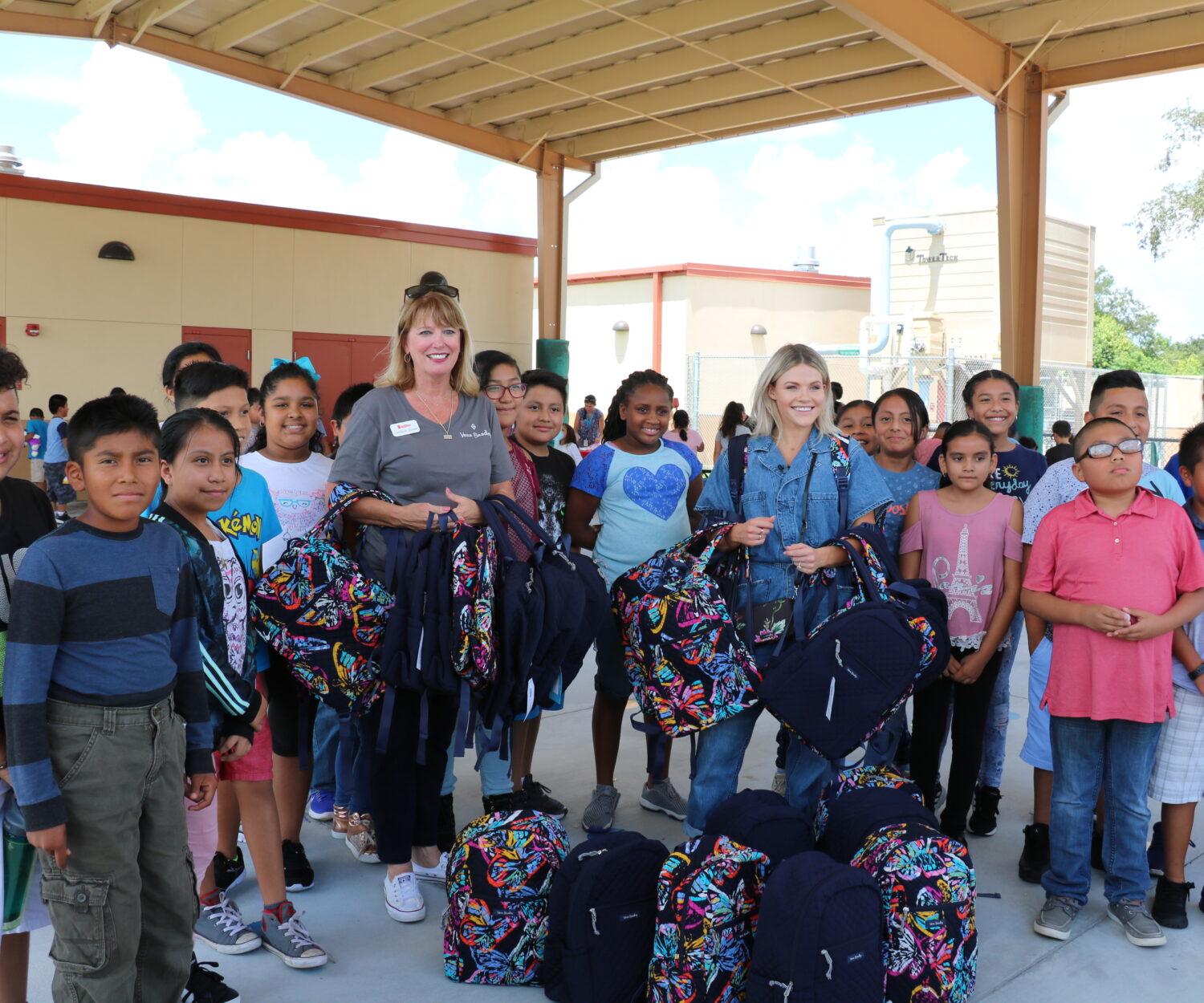 
Blessings in a Backpack SWFL Executive Director Cecilia St. Arnold (with backpacks, left) and “Dancing with the Stars” 

performer Witney Carson (with backpacks, right) at a surprise carnival for Tice Elementary School students.