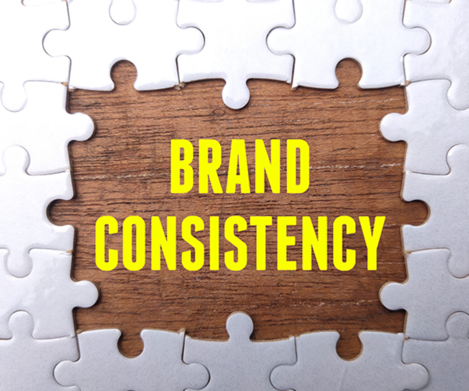 White puzzle with the word BRAND CONSISTENCY. Business concept.